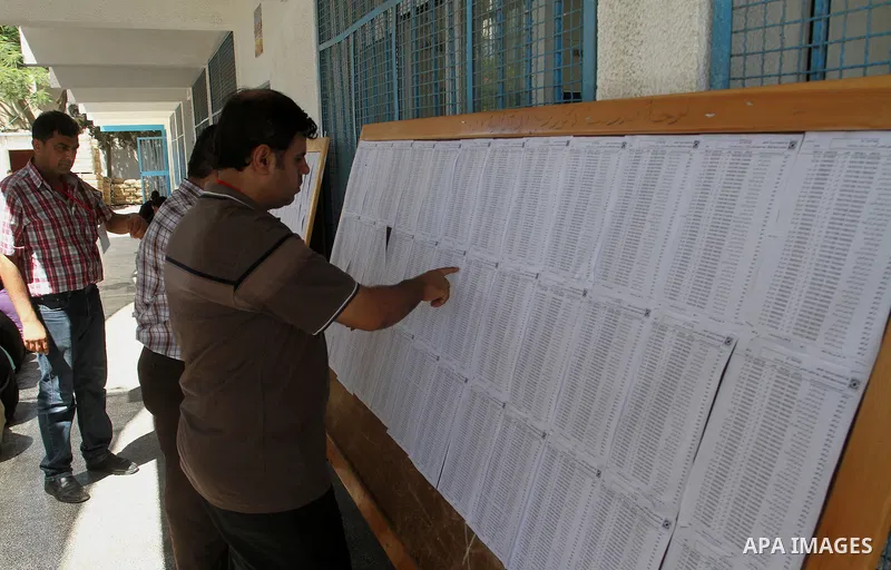 Palestinians look for their names on the registered voters' list at Voter registration centers in Rafah in the southern Gaza strip on July 23, 2016. The Palestinian Central Elections Commission (CEO) announced Saturday t...