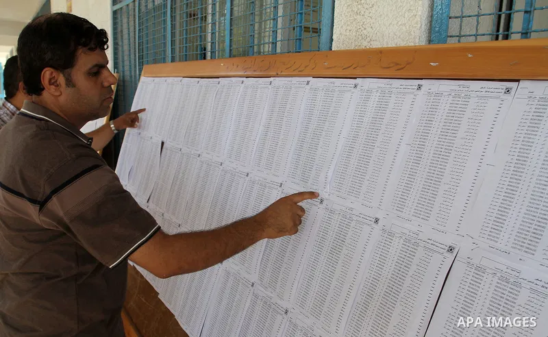 Palestinians look for their names on the registered voters' list at Voter registration centers in Rafah in the southern Gaza strip on July 23, 2016. The Palestinian Central Elections Commission (CEO) announced Saturday t...