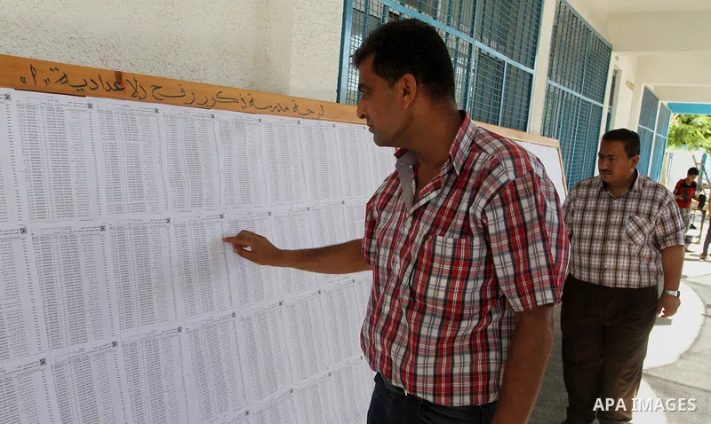 Palestinians look for their names on the registered voters' list at Voter registration centers in Rafah in the southern Gaza strip on July 23, 2016. The Palestinian Central Elections Commission (CEO) announced Saturday t...