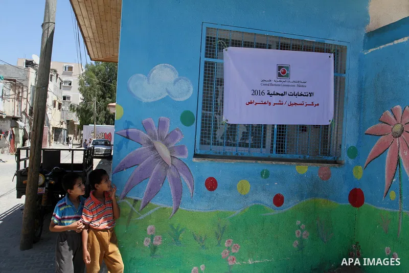 Palestinian boys play outside Voter registration centers in Rafah in the southern Gaza strip on July 23, 2016. The Palestinian Central Elections Commission (CEO) announced Saturday that voter registration centers would b...