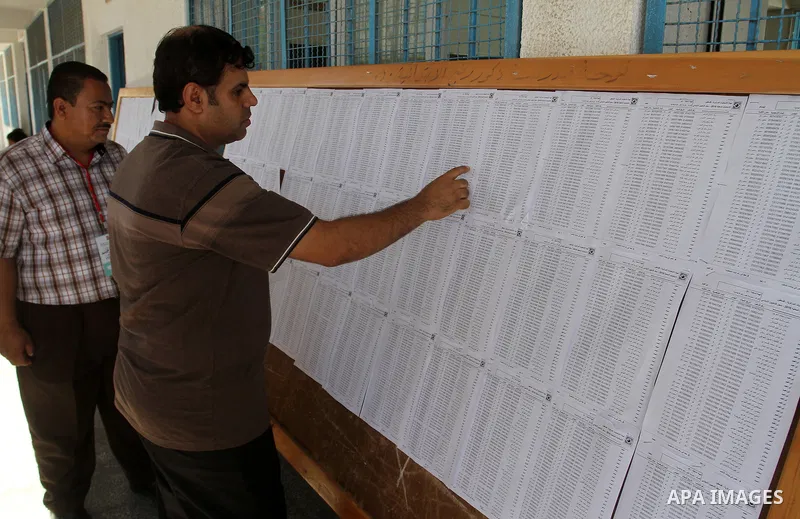 Palestinians look for their names on the registered voters' list at Voter registration centers in Rafah in the southern Gaza strip on July 23, 2016. The Palestinian Central Elections Commission (CEO) announced Saturday t...