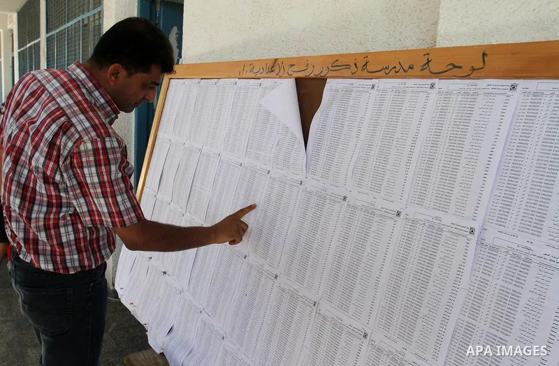 Palestinians look for their names on the registered voters' list at Voter registration centers in Rafah in the southern Gaza strip on July 23, 2016. The Palestinian Central Elections Commission (CEO) announced Saturday t...