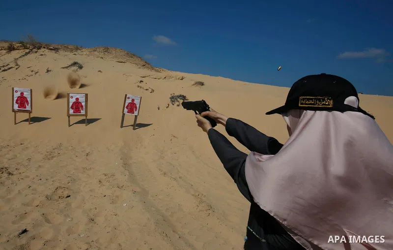 A Palestinian woman fires at a target during a training session for the families of Hamas officials, organized by Hamas-run Security and Protection Service, in Khan Younis in the southern Gaza Strip July 24, 2016. Photo...