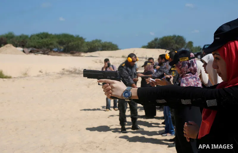 A Palestinian woman fires at a target during a training session for the families of Hamas officials, organized by Hamas-run Security and Protection Service, in Khan Younis in the southern Gaza Strip July 24, 2016. Photo...