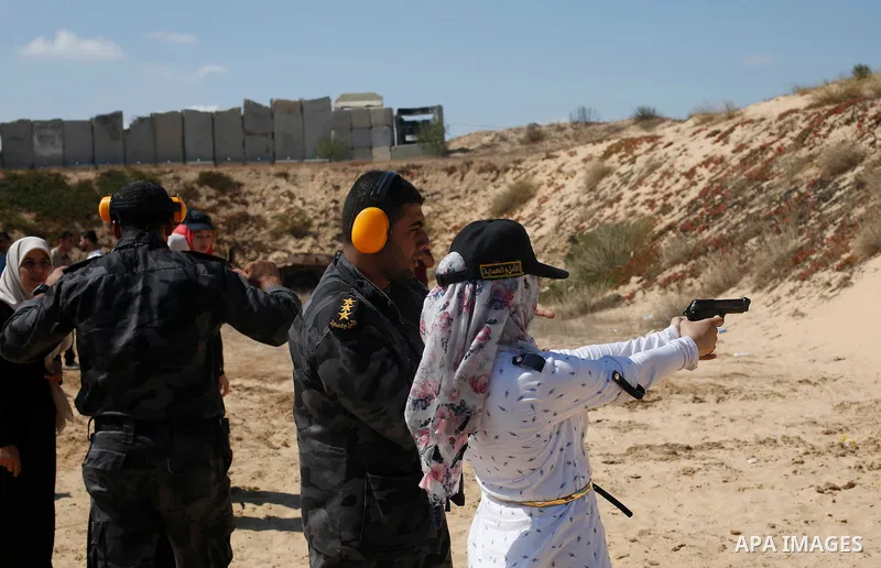 A Palestinian woman fires at a target during a training session for the families of Hamas officials, organized by Hamas-run Security and Protection Service, in Khan Younis in the southern Gaza Strip July 24, 2016. Photo...
