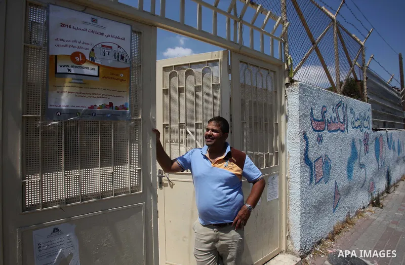 A Palestinian man looks for his name on the registered voters' list at Voter registration centers in the West Bank city of Nablus on July 24, 2016. The Palestinian Central Elections Commission (CEO) announced Saturday th...
