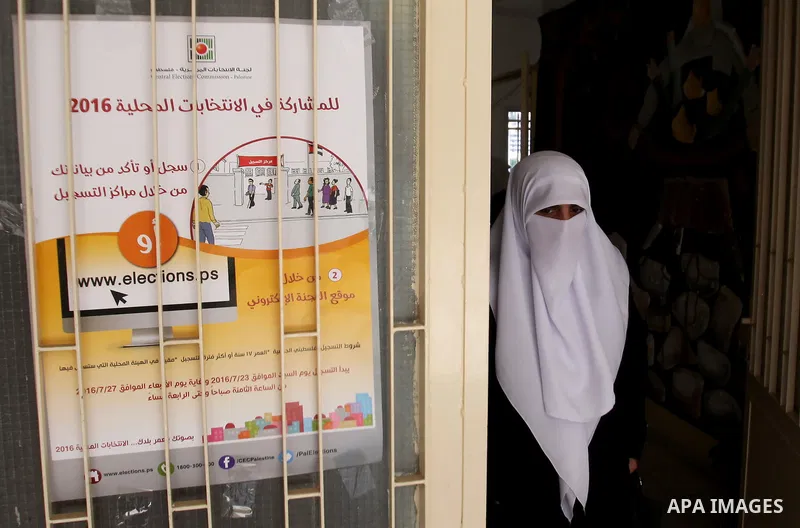 A Palestinian woman looks for her name on the registered voters' list at Voter registration centers in the West Bank city of Nablus on July 24, 2016. The Palestinian Central Elections Commission (CEO) announced Saturday...