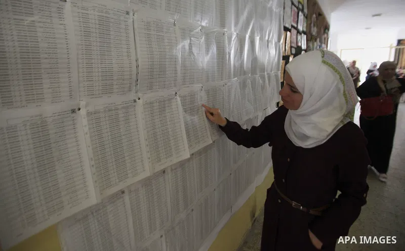A Palestinian woman looks for her name on the registered voters' list at Voter registration centers in the West Bank city of Nablus on July 24, 2016. The Palestinian Central Elections Commission (CEO) announced Saturday...