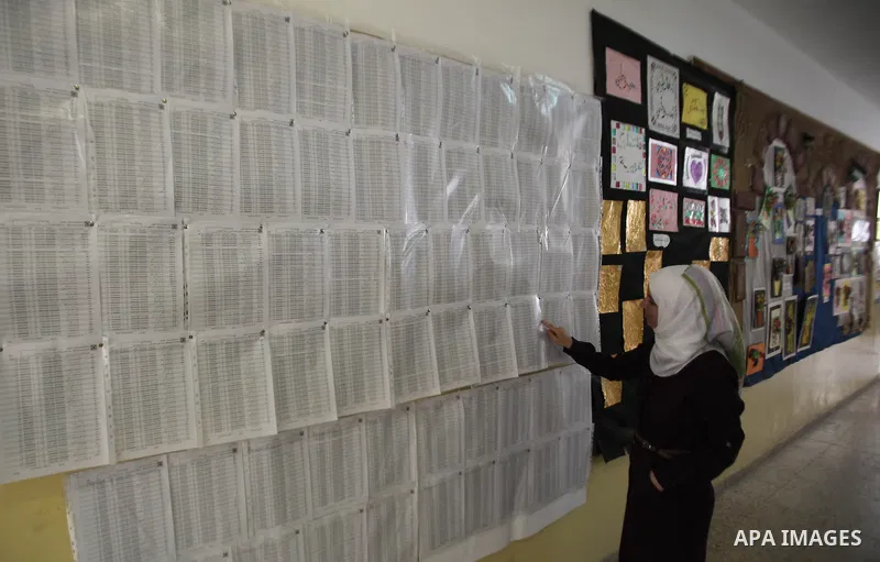 A Palestinian woman looks for her name on the registered voters' list at Voter registration centers in the West Bank city of Nablus on July 24, 2016. The Palestinian Central Elections Commission (CEO) announced Saturday...