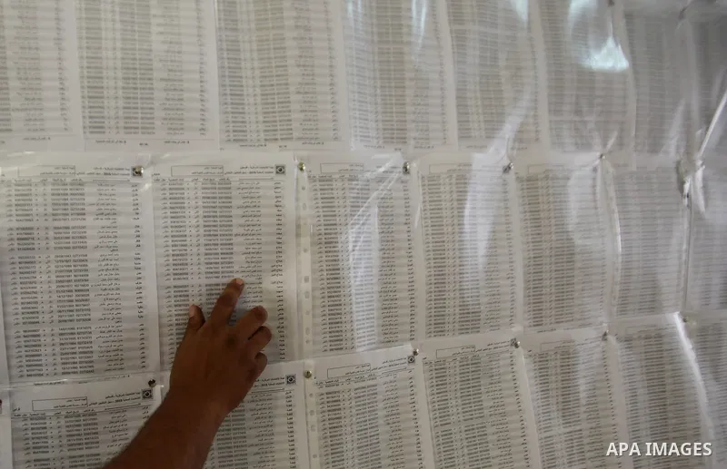 A Palestinian man looks for his name on the registered voters' list at Voter registration centers in the West Bank city of Nablus on July 24, 2016. The Palestinian Central Elections Commission (CEO) announced Saturday th...