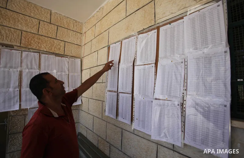 A Palestinian man looks for his name on the registered voters' list at Voter registration centers in the West Bank city of Nablus on July 24, 2016. The Palestinian Central Elections Commission (CEO) announced Saturday th...