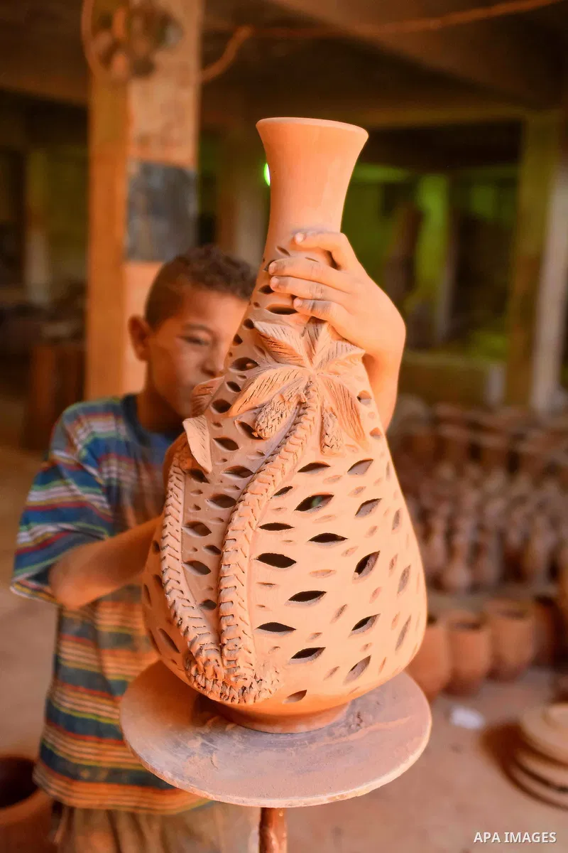 An Egyptian boy works at a pottery workshop in Cairo, on July 24, 2016. Pottery is an ancient and traditional craft in Egypt. Local workshops usually produce products such as bowls, pitchers, flower pots, and vases. Phot...