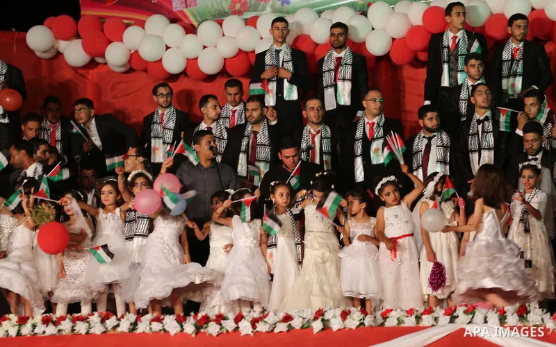 Girls accompany grooms during a mass wedding for 340 couples organized by Hamas movement in Beit Lahiya town in the northern Gaza Strip July 24, 2016. Photo by Mohammed Asad