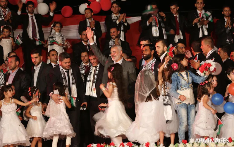 Girls accompany grooms during a mass wedding for 340 couples organized by Hamas movement in Beit Lahiya town in the northern Gaza Strip July 24, 2016. Photo by Mohammed Asad