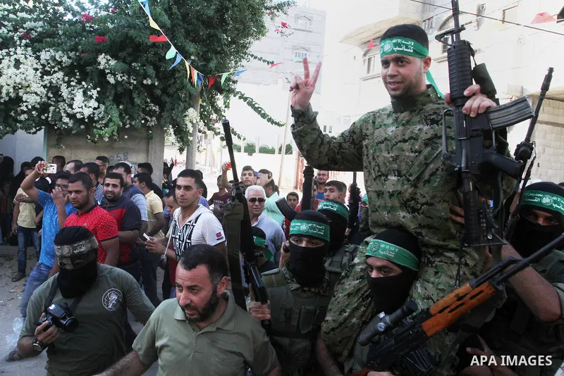 Freed Palestinian prisoner Mohammed al-Bashiti, who served 12 years in an Israeli jail after he was convicted of being a member of Hamas's armed wing, waves as he sits on the shoulders of a Hamas militant upon his releas...