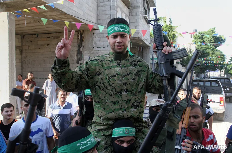 Freed Palestinian prisoner Mohammed al-Bashiti, who served 12 years in an Israeli jail after he was convicted of being a member of Hamas's armed wing, waves as he sits on the shoulders of a Hamas militant upon his releas...