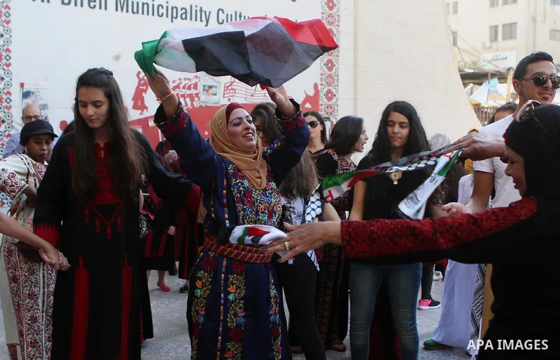 Palestinians perform a traditional dance during a ceremony of Palestinian Traditional Dress and Heritage Day in the West Bank city of Ramallah, on July 25, 2016. Photo by Shadi Hatem