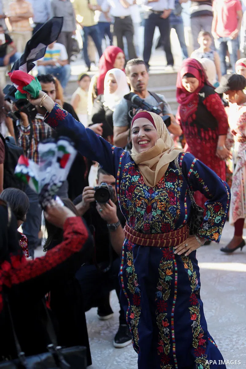 Palestinians perform a traditional dance during a ceremony of Palestinian Traditional Dress and Heritage Day in the West Bank city of Ramallah, on July 25, 2016. Photo by Shadi Hatem