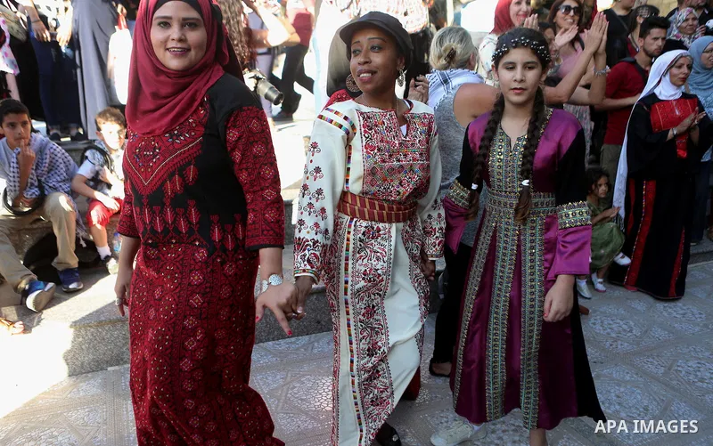 Palestinians perform a traditional dance during a ceremony of Palestinian Traditional Dress and Heritage Day in the West Bank city of Ramallah, on July 25, 2016. Photo by Shadi Hatem