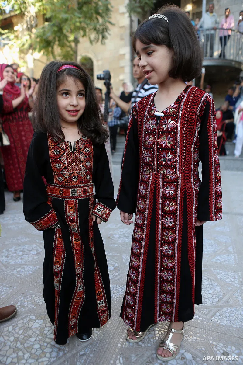 Palestinian girls take part during a ceremony of Palestinian Traditional Dress and Heritage Day in the West Bank city of Ramallah, on July 25, 2016. Photo by Shadi Hatem