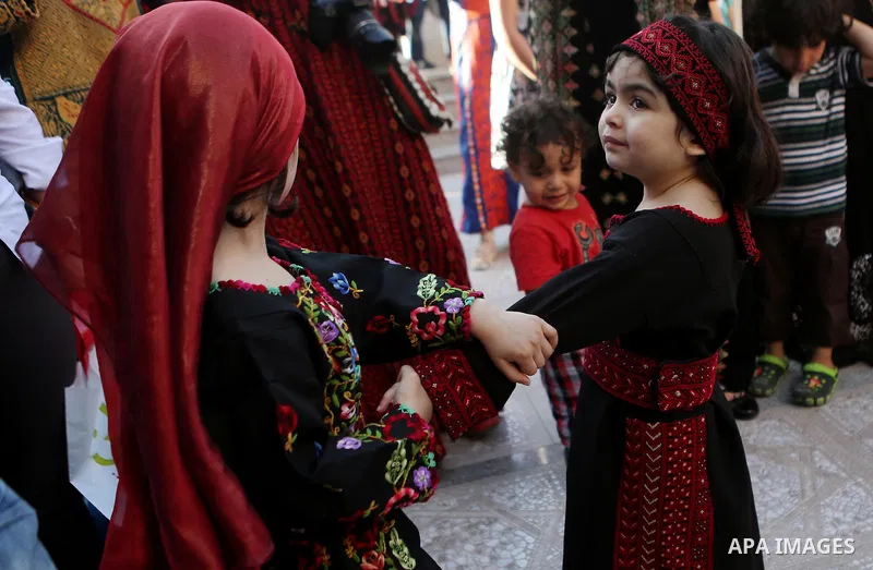 Palestinian girls take part during a ceremony of Palestinian Traditional Dress and Heritage Day in the West Bank city of Ramallah, on July 25, 2016. Photo by Shadi Hatem