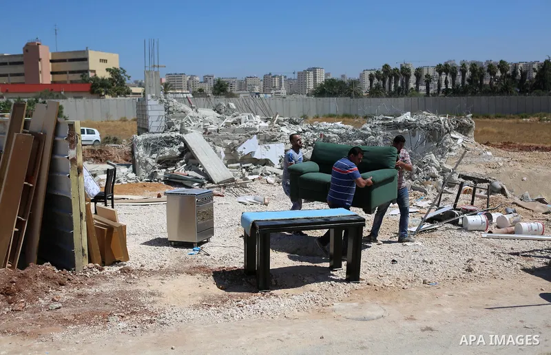 Palestinians inspect the rubble of a Palestinian house after it was demolished by Israeli troops in the West Bank village of Qalandia near Ramallah July 26, 2016. Photo by Shadi Hatem
