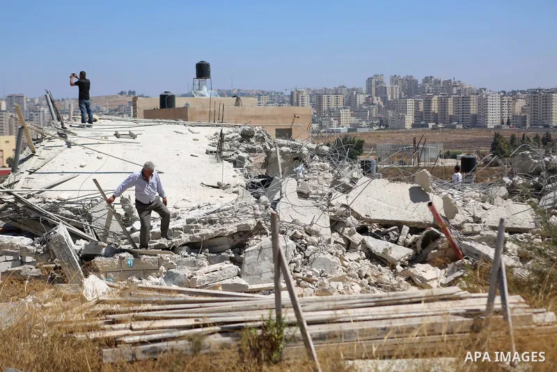 Palestinians inspect the rubble of a Palestinian house after it was demolished by Israeli troops in the West Bank village of Qalandia near Ramallah July 26, 2016. Photo by Shadi Hatem
