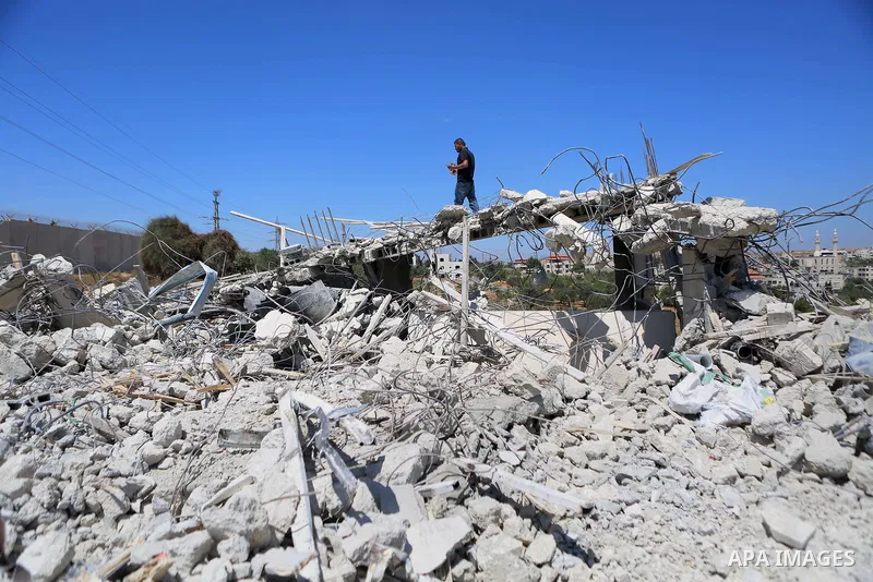 Palestinians inspect the rubble of a Palestinian house after it was demolished by Israeli troops in the West Bank village of Qalandia near Ramallah July 26, 2016. Photo by Shadi Hatem