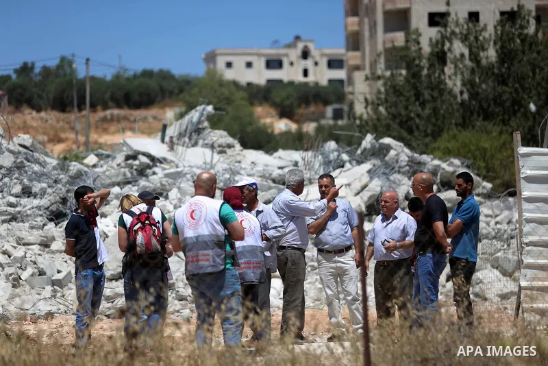 Palestinians inspect the rubble of a Palestinian house after it was demolished by Israeli troops in the West Bank village of Qalandia near Ramallah July 26, 2016. Photo by Shadi Hatem