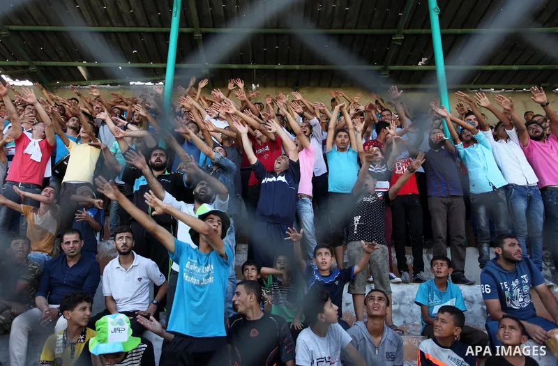 Palestinian spectators watch the first leg of the Palestine Cup final soccer match between Gaza Strip's Khan Younis Youth and Hebron's Al-Ahly at al-Yarmouk stadium in Gaza City July 26, 2016. Photo by Ashraf Amra