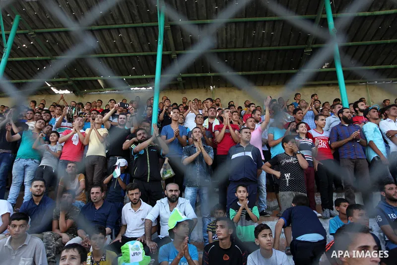 Palestinian spectators watch the first leg of the Palestine Cup final soccer match between Gaza Strip's Khan Younis Youth and Hebron's Al-Ahly at al-Yarmouk stadium in Gaza City July 26, 2016. Photo by Ashraf Amra
