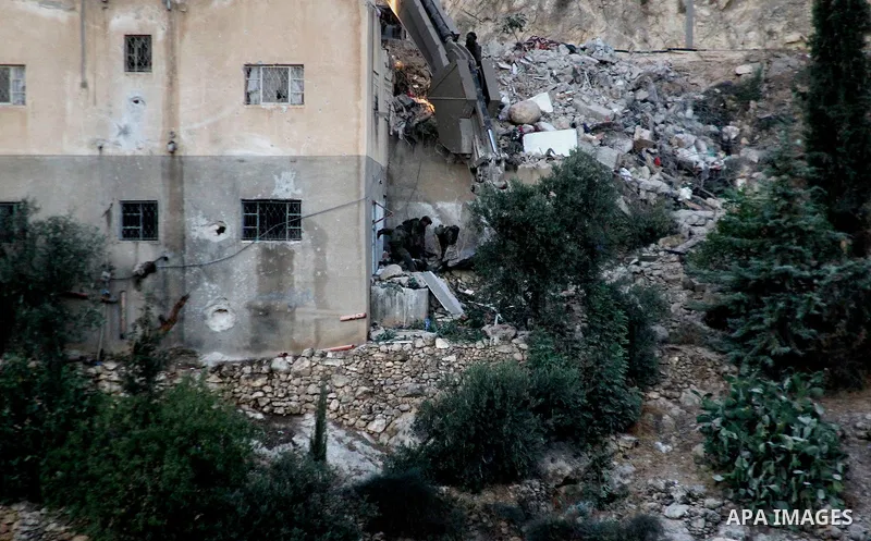 Israeli soldiers evacuate the body of Palestinian Mohammad al-Fakih after he was shot dead by the Israeli troops during a raid on a house in which he was hiding out in the West Bank village of Surif, near Hebron July 27,...
