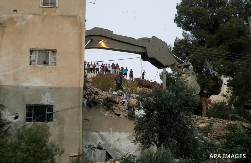 Israeli soldiers evacuate the body of Palestinian Mohammad al-Fakih after he was shot dead by the Israeli troops during a raid on a house in which he was hiding out in the West Bank village of Surif, near Hebron July 27,...