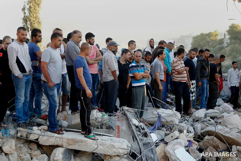 Palestinians check the damage to a house where Mohammad al-Fakih, who was shot dead by Israeli troops during a raid on a house in which he was hiding out, in the West Bank village of Surif, near Hebron July 27, 2016. Pho...