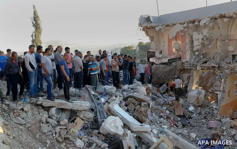 Palestinians check the damage to a house where Mohammad al-Fakih, who was shot dead by Israeli troops during a raid on a house in which he was hiding out, in the West Bank village of Surif, near Hebron July 27, 2016. Pho...