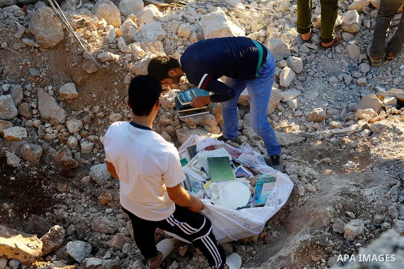 Palestinians check the damage to a house where Mohammad al-Fakih, who was shot dead by Israeli troops during a raid on a house in which he was hiding out, in the West Bank village of Surif, near Hebron July 27, 2016. Pho...
