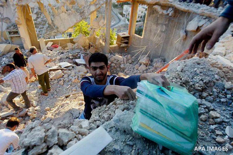 Palestinians check the damage to a house where Mohammad al-Fakih, who was shot dead by Israeli troops during a raid on a house in which he was hiding out, in the West Bank village of Surif, near Hebron July 27, 2016. Pho...