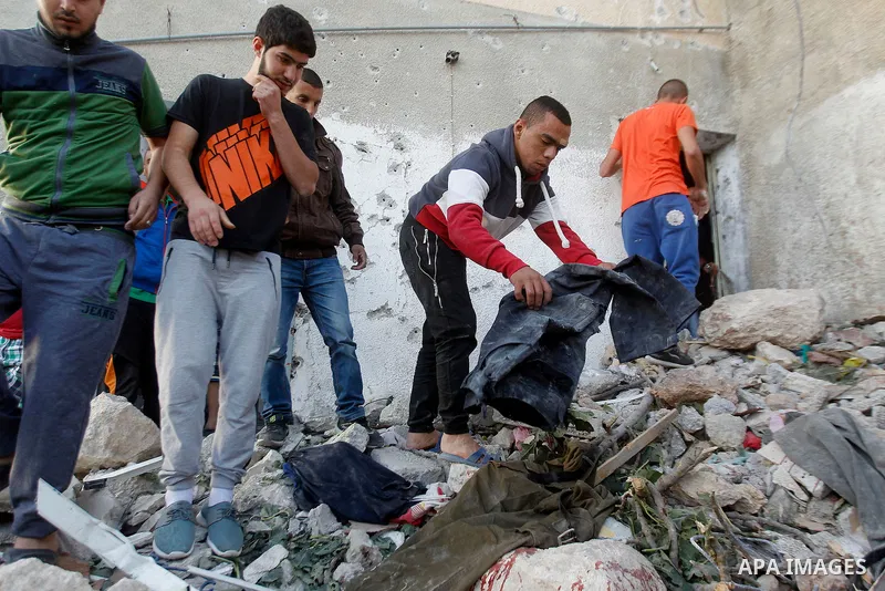Palestinians check the clothes of Mohammad al-Fakih, who was shot dead by Israeli troops during a raid on a house in which he was hiding out, in the West Bank village of Surif, near Hebron July 27, 2016. Photo by Wisam H...