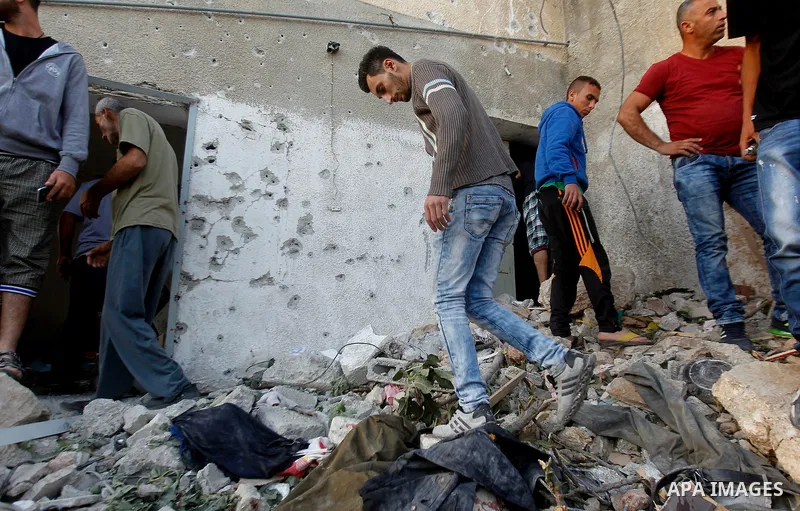 Palestinians check the damage to a house where Mohammad al-Fakih, who was shot dead by Israeli troops during a raid on a house in which he was hiding out, in the West Bank village of Surif, near Hebron July 27, 2016. Pho...