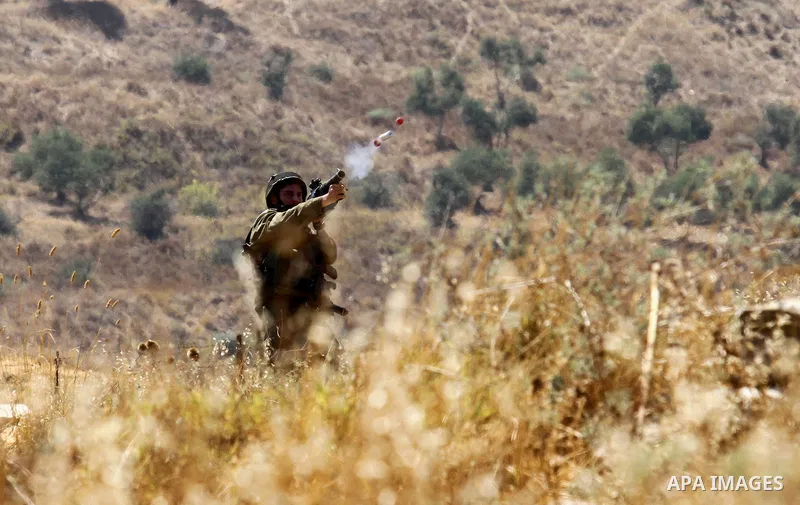 A member of Israeli security forces takes position as Palestinian activists from the Popular Front of the Liberation of Palestine (PFLP) demonstrate at the Hawara checkpoint near the West Bank city of Nablus on July 29,...