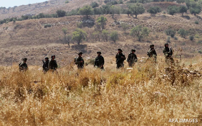 Israeli security forces take position as Palestinian activists from the Popular Front of the Liberation of Palestine (PFLP) demonstrate at the Hawara checkpoint near the West Bank city of Nablus on July 29, 2016, against...