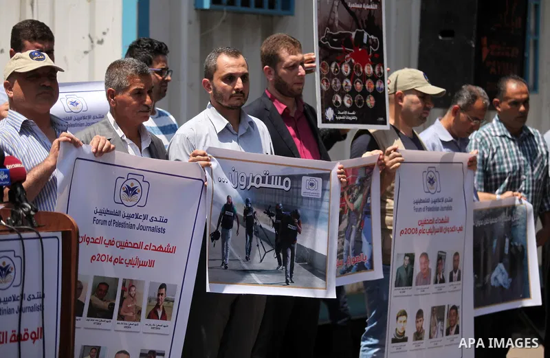Palestinian Journalists hold banners during a protest calling for stop the Israeli violence against journalists in front of the high commissioner for human rights headquarters in Gaza City, on July 31, 2016. Photo by Ash...