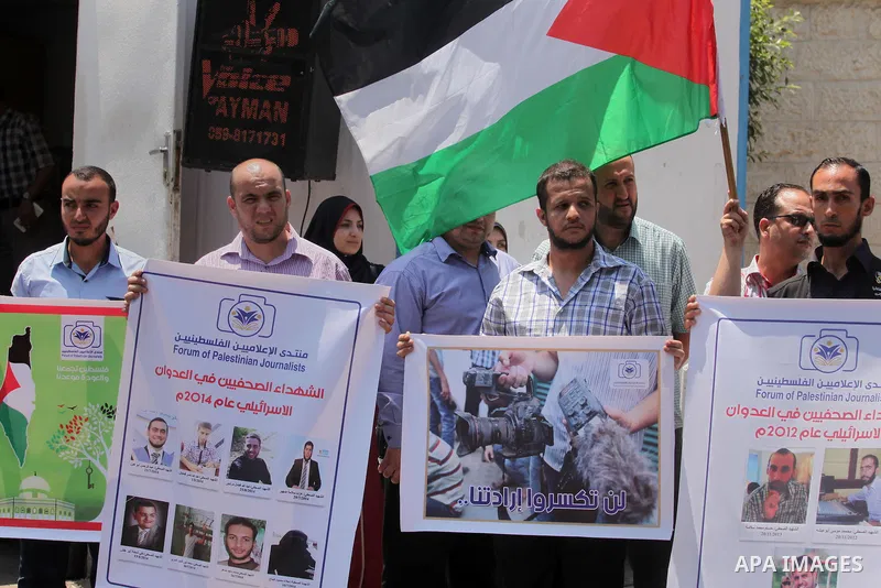 Palestinian Journalists hold banners during a protest calling for stop the Israeli violence against journalists in front of the high commissioner for human rights headquarters in Gaza City, on July 31, 2016. Photo by Ash...