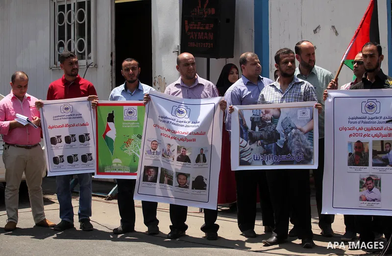 Palestinian Journalists hold banners during a protest calling for stop the Israeli violence against journalists in front of the high commissioner for human rights headquarters in Gaza City, on July 31, 2016. Photo by Ash...