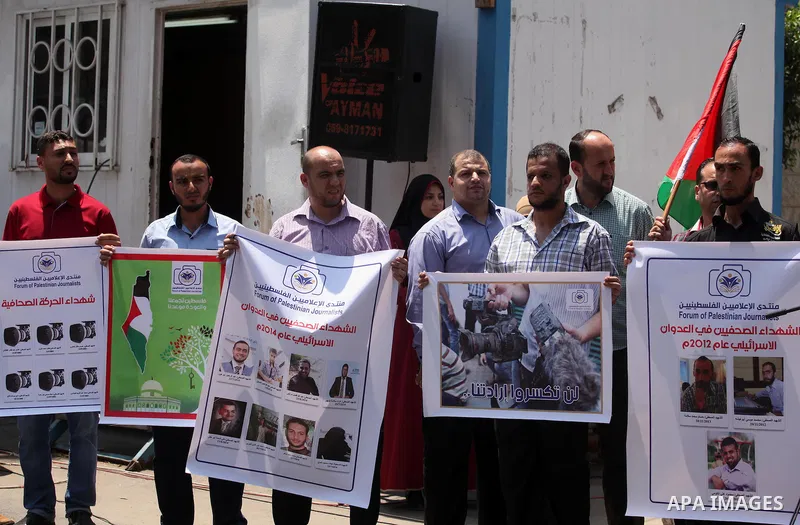 Palestinian Journalists hold banners during a protest calling for stop the Israeli violence against journalists in front of the high commissioner for human rights headquarters in Gaza City, on July 31, 2016. Photo by Ash...