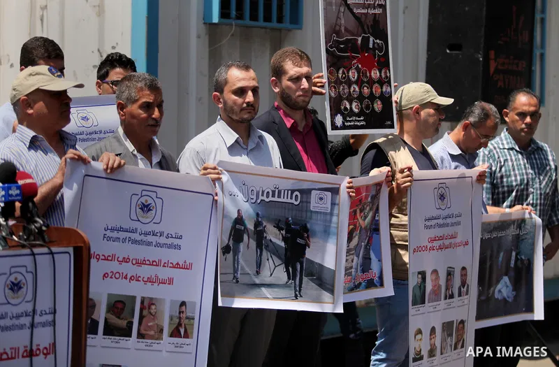 Palestinian Journalists hold banners during a protest calling for stop the Israeli violence against journalists in front of the high commissioner for human rights headquarters in Gaza City, on July 31, 2016. Photo by Ash...