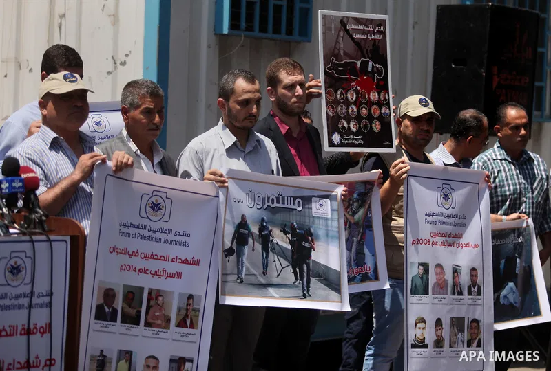 Palestinian Journalists hold banners during a protest calling for stop the Israeli violence against journalists in front of the high commissioner for human rights headquarters in Gaza City, on July 31, 2016. Photo by Ash...