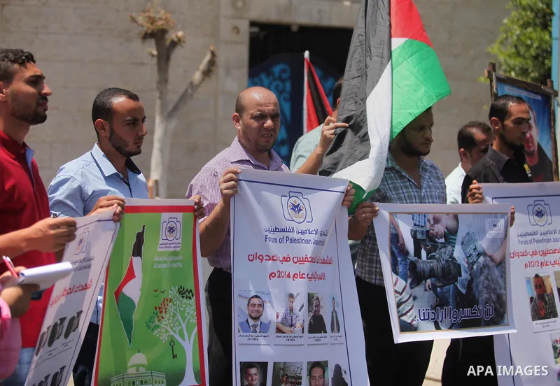 Palestinian Journalists hold banners during a protest calling for stop the Israeli violence against journalists in front of the high commissioner for human rights headquarters in Gaza City, on July 31, 2016. Photo by Ash...