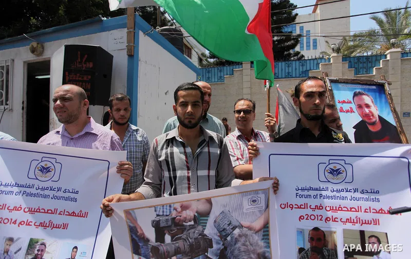 Palestinian Journalists hold banners during a protest calling for stop the Israeli violence against journalists in front of the high commissioner for human rights headquarters in Gaza City, on July 31, 2016. Photo by Ash...