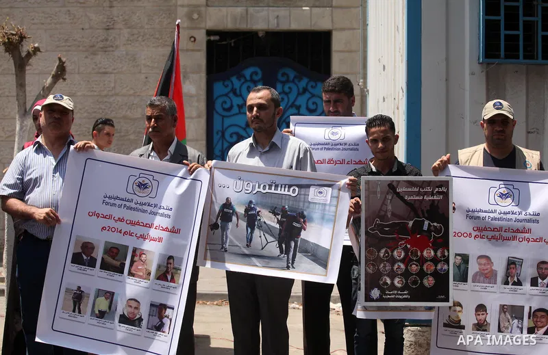 Palestinian Journalists hold banners during a protest calling for stop the Israeli violence against journalists in front of the high commissioner for human rights headquarters in Gaza City, on July 31, 2016. Photo by Ash...